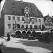 Skioptikonbild med motiv av marknad framför rådhuset i Heilbronn.
Bilden har förvarats i kartong märkt: Resan 1908. Heilbronn 4. Wimpfen 5. Text på bild: 