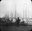 Skioptikonbild med motiv av man i hamn i Lübeck.
Bilden har förvarats i kartong märkt: Lybeck 1903.