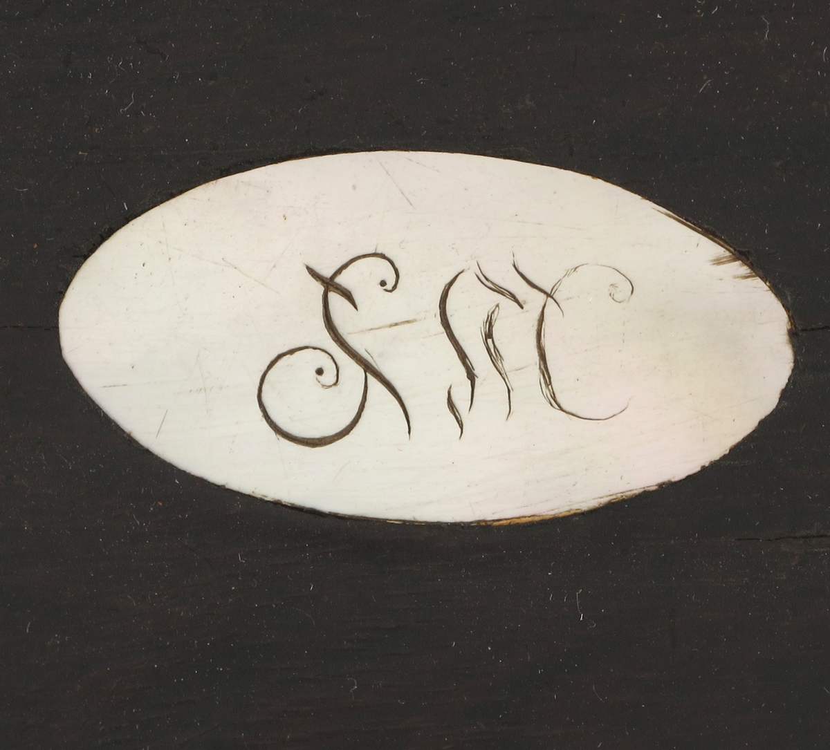 Perlemors oval midt på lokket/ Perlemors nøkkelskilt.