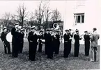 Mössebergs musikkår 1954. Dirigent: Sigfrid Strand. Första raden: Arne Brissman, Gösta Johansson, Stig Johansson, Lennart Gustavsson, John W. Gustavsson. Andra raden: Oskar Nilsson, Ingvar Arrestig, Klaes Bergström, Olle Alsterfjärd, basunen längst ut, osäker kan vara Paul Lindelöv. Bastrumma Åke Öberg, beckar Arnold Ewertz, virveltrumma Göte Larsson och Tore Andersson.