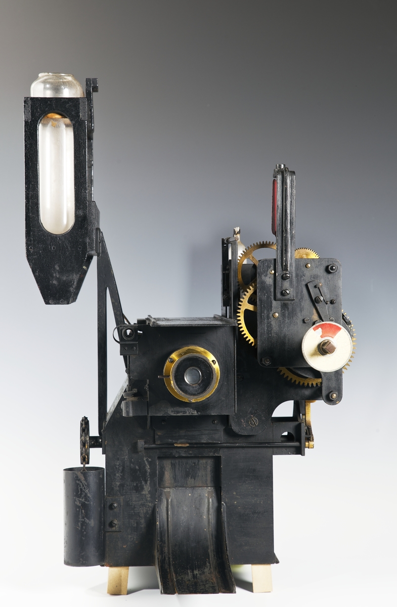 Fotoautomat "Bosco" för tillverkning av ferrotypier. Penningautomat för självfotografering.  Den fungerade på så sätt att det ljuskänsliga skiktet placerats i en profilerad plåtbricka som på samma gång var framkallningsskål och sedan ram för fotografiet. I automaten exponerades bilden i lodrätt läge och framkallades sedan med vätskor som portionerades ur behållare. Efter tre minuter var ferrotypen klar och matades ut ur apparaten. Den behövde torka ytterligare och fick enligt anvisningarna inte utsättas för starkt ljus förrän den var torr. Bilden mätte 60x83 mm och levererades i ett etui av papper. Plåtbrickan hade påtryck av reklam och information på baksida och kanter.
Tillbehör: Sockel med 2 st. metallådor för plåtar, 10 st. plåtar ("W.H.C Bernitt Original Bosco Platte Hamburg 23 ...), överdel med kamera, mekanism, mekanism för framkallning m.m. nyckel till verket.