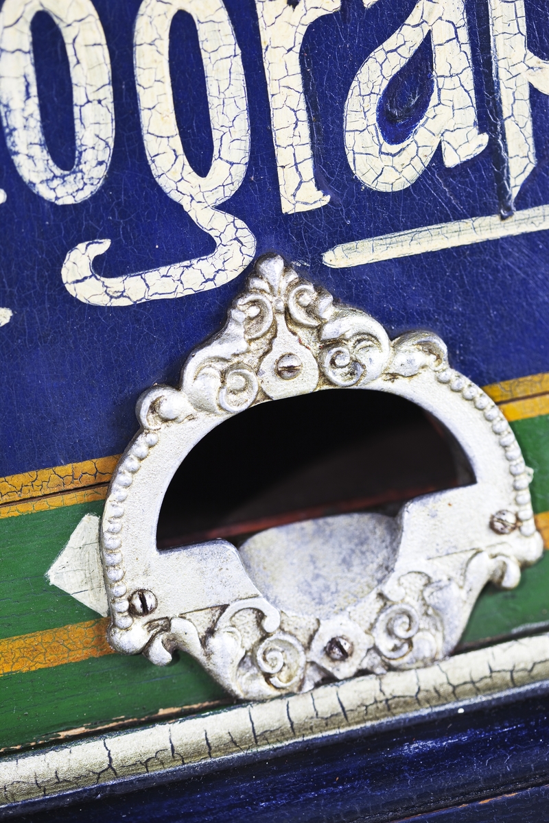 Fotoautomat "Bosco" för tillverkning av ferrotypier. Penningautomat för självfotografering.  Den fungerade på så sätt att det ljuskänsliga skiktet placerats i en profilerad plåtbricka som på samma gång var framkallningsskål och sedan ram för fotografiet. I automaten exponerades bilden i lodrätt läge och framkallades sedan med vätskor som portionerades ur behållare. Efter tre minuter var ferrotypen klar och matades ut ur apparaten. Den behövde torka ytterligare och fick enligt anvisningarna inte utsättas för starkt ljus förrän den var torr. Bilden mätte 60x83 mm och levererades i ett etui av papper. Plåtbrickan hade påtryck av reklam och information på baksida och kanter.
Tillbehör: Sockel med 2 st. metallådor för plåtar, 10 st. plåtar ("W.H.C Bernitt Original Bosco Platte Hamburg 23 ...), överdel med kamera, mekanism, mekanism för framkallning m.m. nyckel till verket.