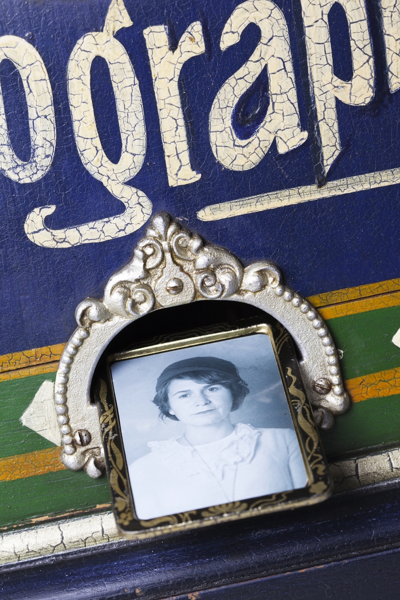 Fotoautomat "Bosco" för tillverkning av ferrotypier. Penningautomat för självfotografering.  Den fungerade på så sätt att det ljuskänsliga skiktet placerats i en profilerad plåtbricka som på samma gång var framkallningsskål och sedan ram för fotografiet. I automaten exponerades bilden i lodrätt läge och framkallades sedan med vätskor som portionerades ur behållare. Efter tre minuter var ferrotypen klar och matades ut ur apparaten. Den behövde torka ytterligare och fick enligt anvisningarna inte utsättas för starkt ljus förrän den var torr. Bilden mätte 60x83 mm och levererades i ett etui av papper. Plåtbrickan hade påtryck av reklam och information på baksida och kanter.
Tillbehör: Sockel med 2 st. metallådor för plåtar, 10 st. plåtar ("W.H.C Bernitt Original Bosco Platte Hamburg 23 ...), överdel med kamera, mekanism, mekanism för framkallning m.m. nyckel till verket.