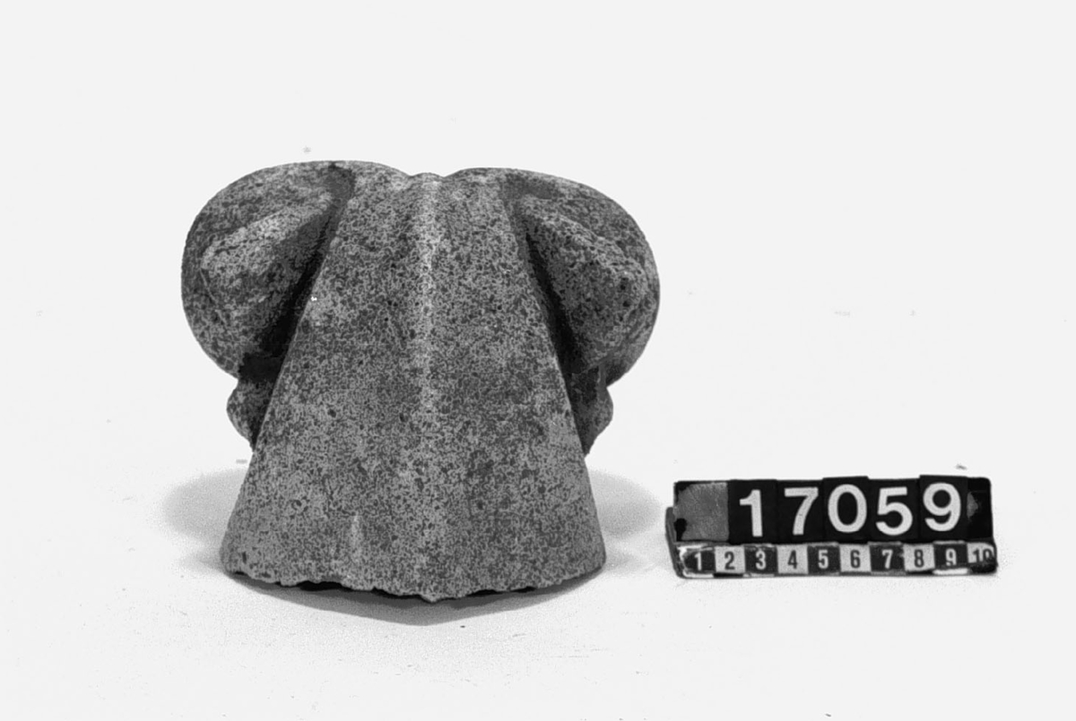 Fyra figurer av betong från den skulpturala utsmyckningen av Uppsala Domkyrka. Bl.a. slutstycke av takränna i form av groteskt djävulshuvud.