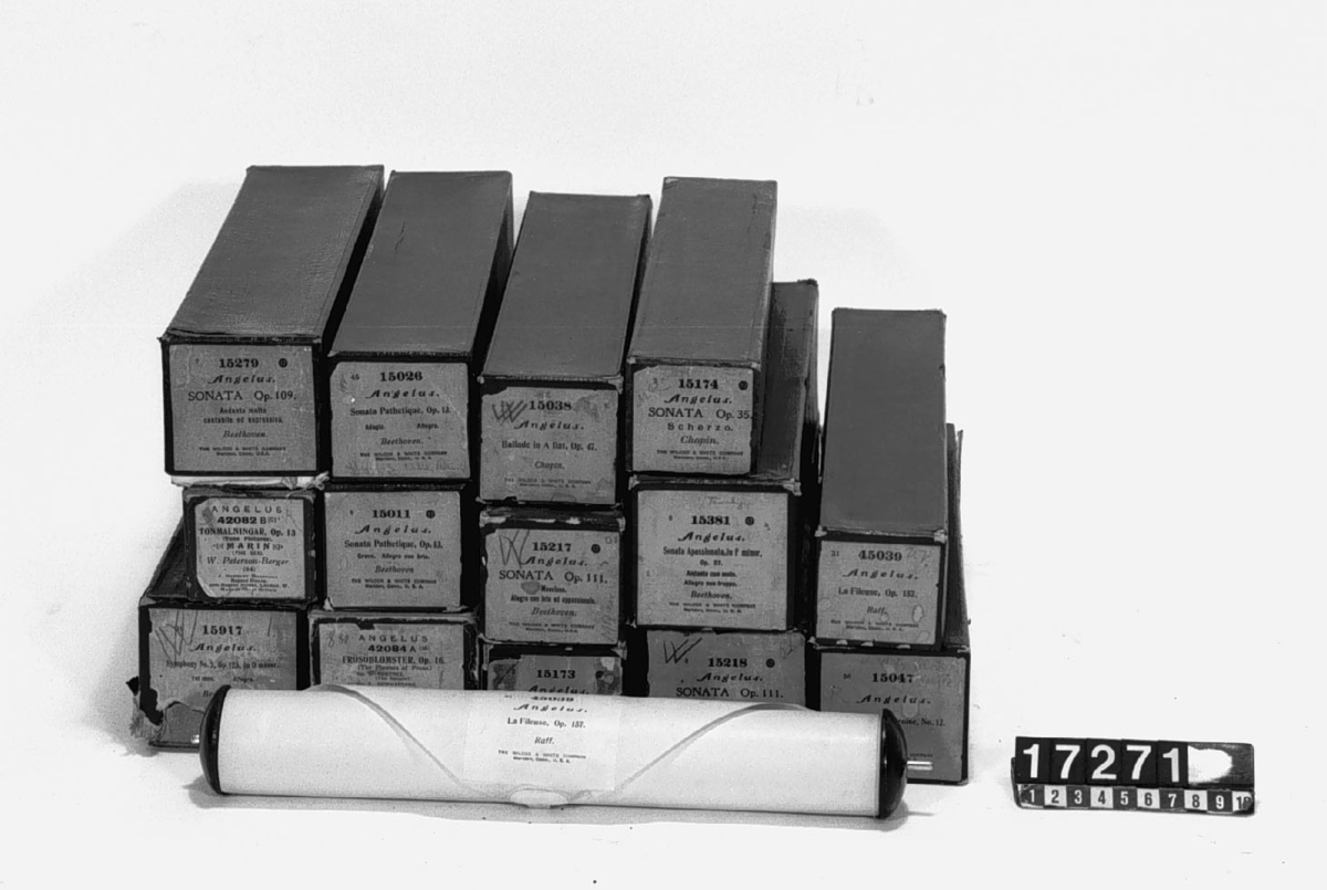 Autopiano-tillsats med trampbälgar och perforerade notrullar av papper, 17 st. notrullar i originalaskar. "Angelus (Patented) J. Herbert Marshall Regent House (Regent St. London) Wilcox & White Makers Meriden Conn. U.S.A." 
Ingående notrullar, se bilagd fil samt TM17271:2-3. Omfattar kompositioner av Liszt, Saint-Saëns, Chopin, Beethoven, Peterson-Berger samt Raff.