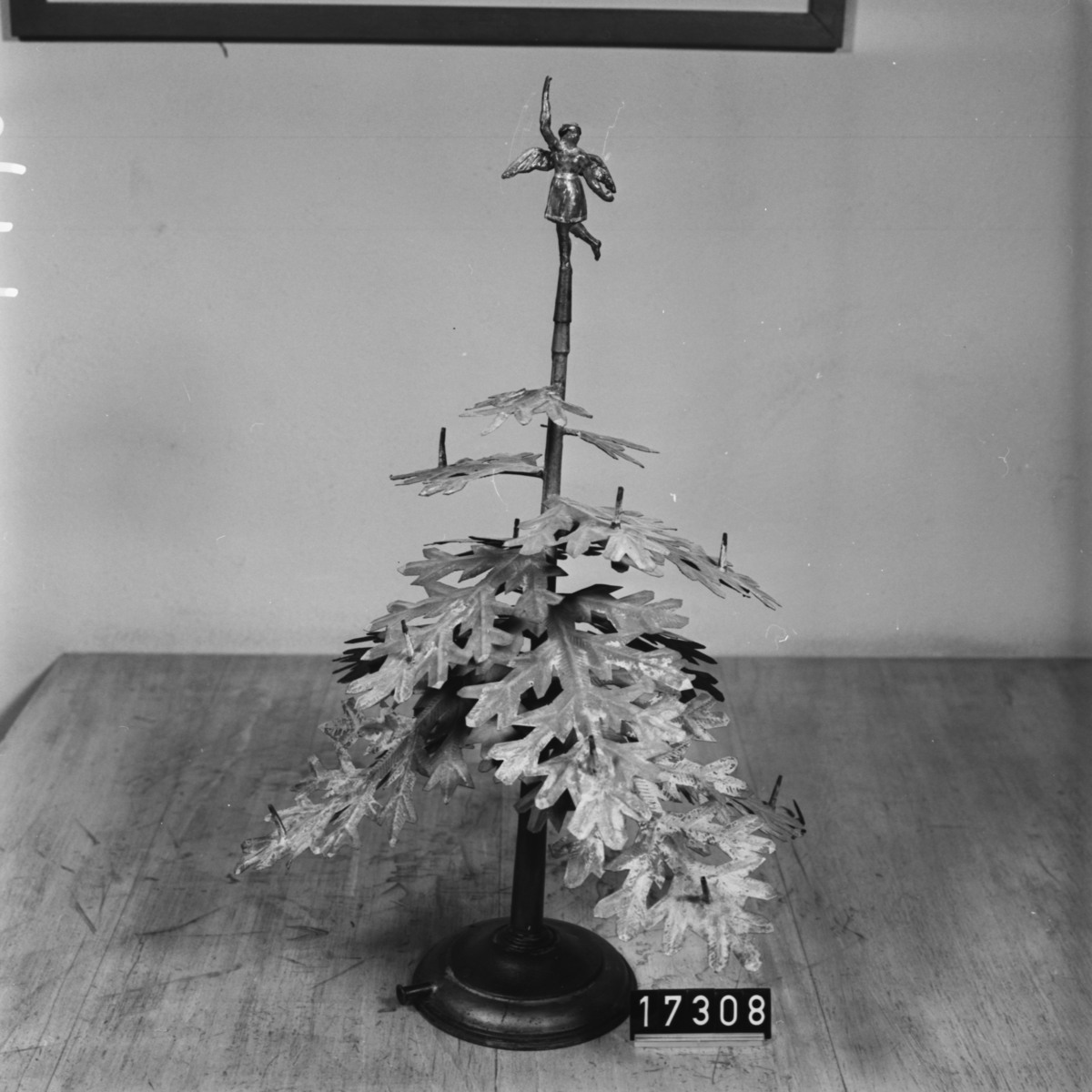 Grönmålad julgran för lysgasanvändning. Tillverkad av förtent bleckplåt med munstycken för gaslågor. Topprydnad (ängel) saknas dock.