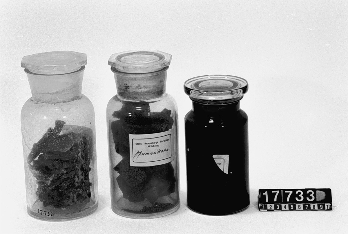 Prov på olika slag av biprodukter från sulfitmassefabrikation. I flaskor: sulfitkvistmassa, bränd, mesa, humuskoks, såpa. Humuskoks. H:220, D:100, Vikt:1,32. Svart. Sulfitkvistmassa. H:220, D:105, Vikt:1,21. Brun. I bitar. ? - H:180. D:95, Vikt:1,33. Svart,etiketten borta. Brändmesa. H:230, D:100. Vikt:1,9. Vitgrå.