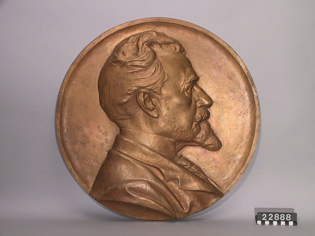 Medaljong i brons, över Knut Agat Wallenberg, f. 1853, d. 1938, höger profil, efter modell, signerad Erik Lindberg.