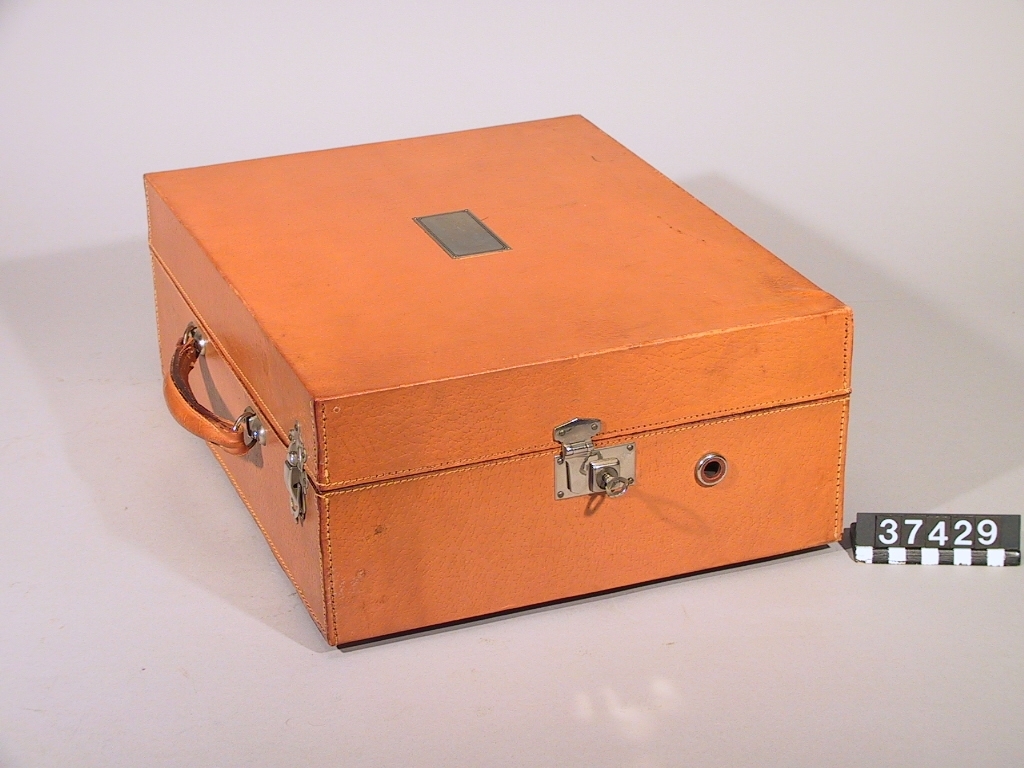 Resegrammofon, med fjäderverk, stiftdosa och hastighetsregulator. Läderklädd väska och förnicklade metalldelar.
Tillbehör: 2 vevar och nyckel.