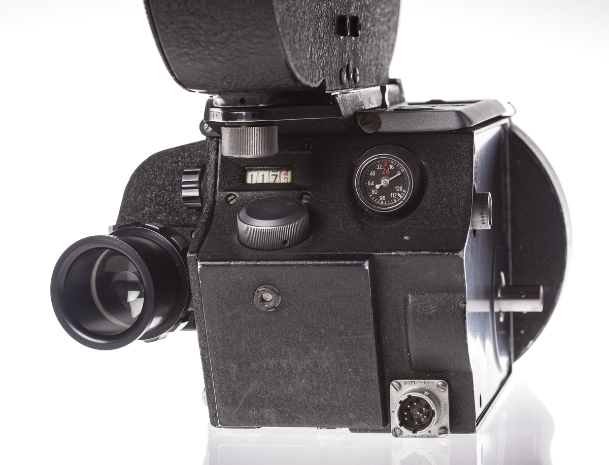 Filmkamera med magasin modell S4L nr 9567, 35 mm filmformat. Ett täcklock av metall som monteras istället för magasin medföljer.  Med Nikon 2x Telekonverter TC 201. Sladd för spänningsmatning. Passande höghastighetsmotor Mitchell modell 11D-2765 ser nr 100 i trälåda.