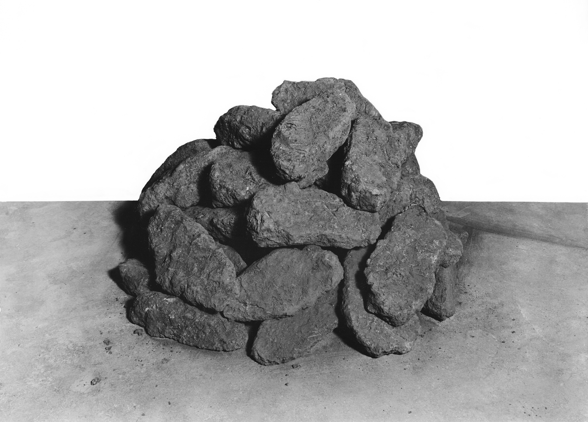 Ursprungligen 59 st. bitar av kluvna osmundstycken. 4 st.skänkta, 55 st. återstår. Bitarna är numrerade I-LVII (2 utan nummer för undersökning). Packade i 3 lådor. Dessutom tillhör en sockerlåda innehållande ved som troligen är järnoxid. Lådan märkt "Rost".