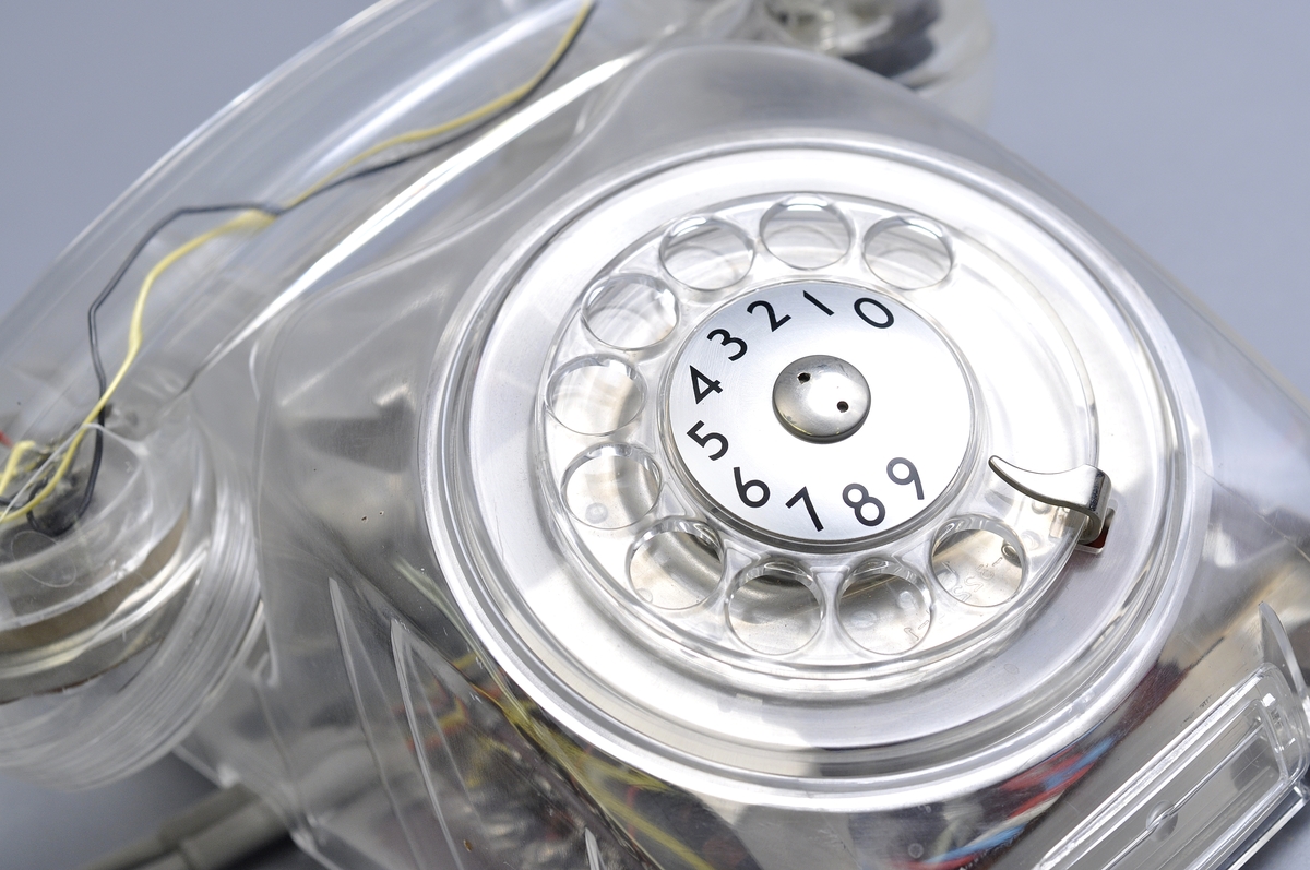 Telefonapparat Dialog för AT-system, huvudapparat, anknytningsapparat till växel och sidoapparat. Bordsmodell av genomskinlig termoplast med fingerskiva. Ringsignalens styrka är ställbar med ett reglage på apparatens undersida.