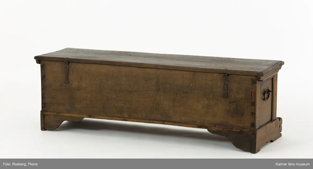 KLM 45387. Ek, järn. Långsmal kista eller bänk i mörk ek med platt lock och rikt utskuren reliefdekor i renässansstil på kistans front. Texten "Anno 1768" och initialerna "MGF" är snidade på fronten. Bandgångjärn på lockets insida och på baksidans utsida. På båda kortsidorna finns smidda bärhandtag av järn. På kistans front finns en nyckelskylt och inne i kistan ett lås av smide. Inne i kistan finns en läddika på den vänstra sida. På frontstyckets ovansida är följande text inristad: "17 IF:MAGRET FREIN:71".