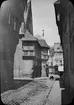 Skioptikonbild med motiv från gata vid Fischmarkt i Halberstadt, mot kyrkan St Martini.
Bilden har förvarats i kartong märkt: Resan 1907.Goslar3. Halberstadt 5. 8.