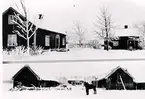 Drygstorp (Drystorp), Gudhem, slutet av 1920-talet. Mannen vid hästen heter Gustav Karlsson. Damen vid lillstugan är Karin Andersson, sedermera Gustav Karlssons fru. Mangårdsbygggnaden revs 1936 och nybyggdes 1937, ladugårdarna som var med halmtak revs omkring 1970 men lillstugan finns kvar.