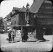 Skioptikonbild med motiv av pojkar vid Rolandsbrunnen, Hildesheim.
Bilden har förvarats i kartong märkt: Hildesheim. Serien E. Text på bild: 