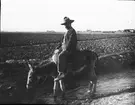 Skioptikonbild med motiv av man på åsna i Granada.
Bilden har förvarats i kartong märkt: Granada 1910.