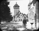 Skioptikonbild med motiv av man på gata i Reutlingen. Bakom syns tornet Tübinger Tor.
Bilden har förvarats i kartong märkt: Granada 1910.