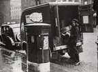 Elbil i det engelska postväsendets tjänst 1943. Den uppsamlade posten lastas på bilen av den kvinnliga chauffören.