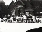 Elever vid Eric Lundviks körskola, samlade kring automobiler framför Biologiska museet på Djurgården, omkring 1915-1920.