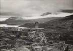 Riksröset vid Riksgränsen. Bakom röset syns ruinerna av lokstallarna, vilka utrymdes då Riksgränsens station slopades.