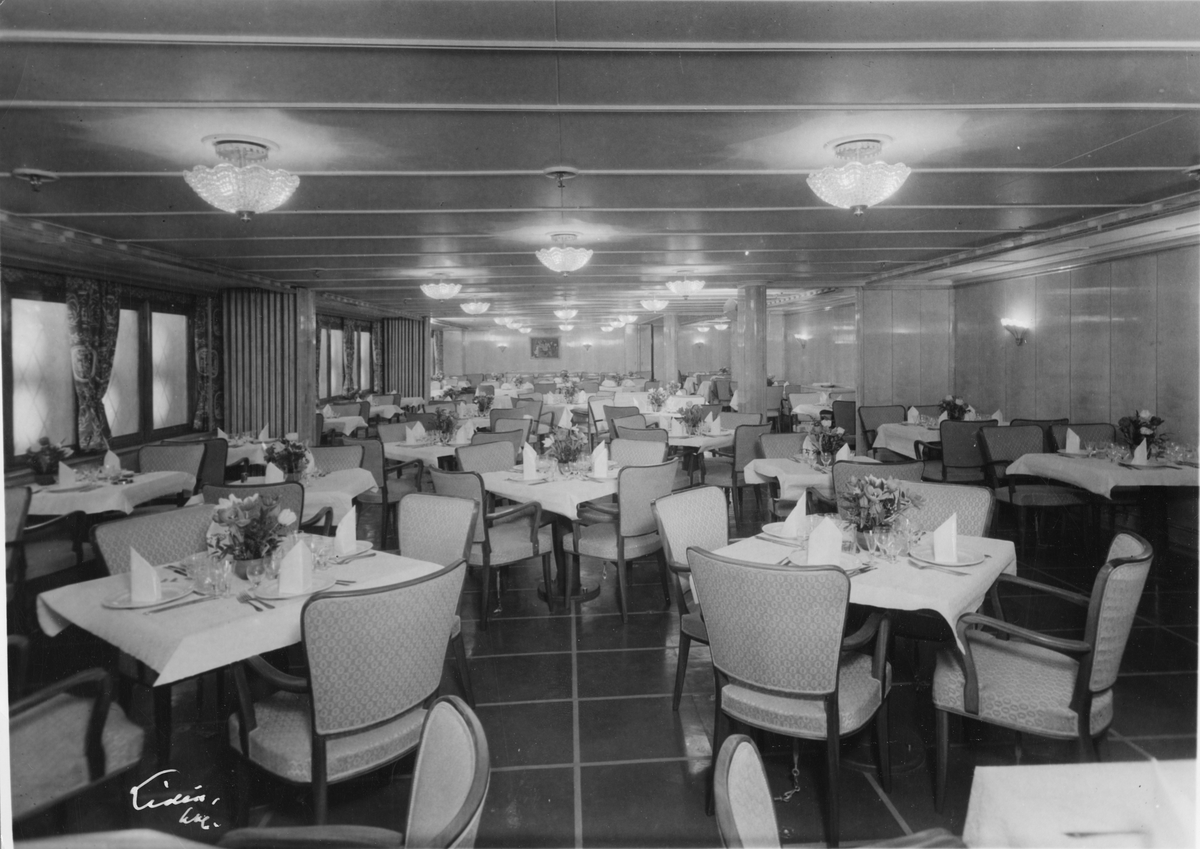 Gemensam matsal för första- och turist klass ombord på M/S 611 Stockholm vid Svenska Amerika Linien. Salongen inredd av arkitekt B. Paulsson.