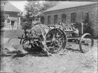 Traktorn är tillverkad ca 1921 av Svenska Motorplogsfabriken i Halmstad. Traktorn är fotograferad utanför fabriken i Halmstad.