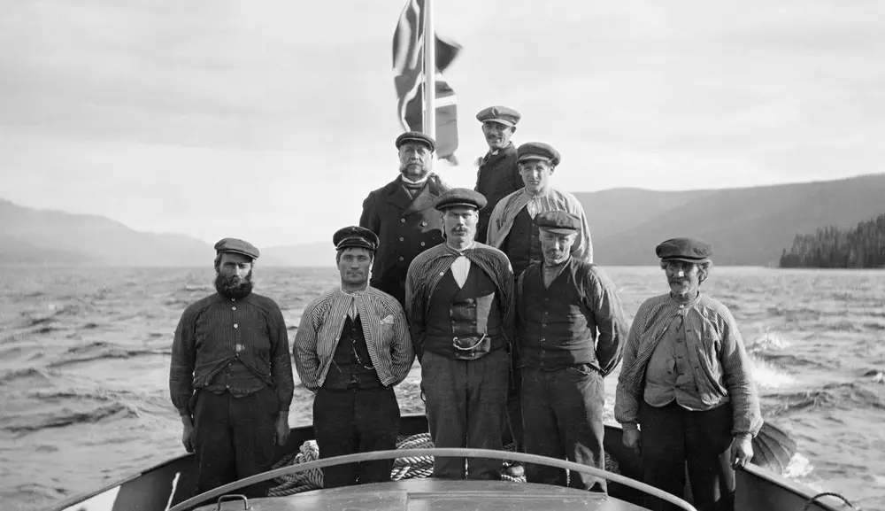 Kaptein og mannskap på tømmerslepebåten D/S Storsjø 29. mai 1915. På dette fotografiet er mannskapet - som besto av åtte mann - samlet i akternenden av båten, som på opptakstidspunktet gikk uten bom.