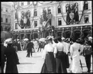 Skioptikonbild från institutionen för fotografi vid Kungliga Tekniska Högskolan. Gustav Adolfs torg i Stockholm, Hotell Rydberg. Bilden är tagen i juli 1905, då det nygifta hertigparet av Skåne, prins Gustav Adolf (sedermera kung Gustav VI Adolf) och prinsessan Margareta, mottogs i Stockholm.