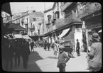 Skioptikonbild från institutionen för fotografi vid Kungliga Tekniska Högskolan. Bilden är troligen tagen av John Hertzberg under en resa i Europa. Hertzberg blev docent i fotografi 1921vid Kungliga Tekniska Högskolan i Stockholm. Gatuliv.