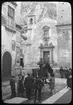 Skioptikonbild från institutionen för fotografi vid Kungliga Tekniska Högskolan. Bilden är troligtvis tagen i Taormina på Sicilien av John Hertzberg under en resa i Europa. Hertzberg blev docent i fotografi 1921vid Kungliga Tekniska Högskolan i Stockholm. Gatubild som visar pojkar på en kärra dragna av en åsna.