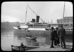 Skioptikonbild från institutionen för fotografi vid Kungliga Tekniska Högskolan. Motiv föresällande ångfartyg med passagerare, sannolikt nära Neapel i Italien. Bilden är troligen tagen av John Hertzberg under en resa i Europa.