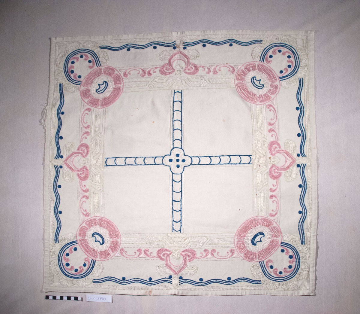 Bomullslerret, falda og brodert med attersting.