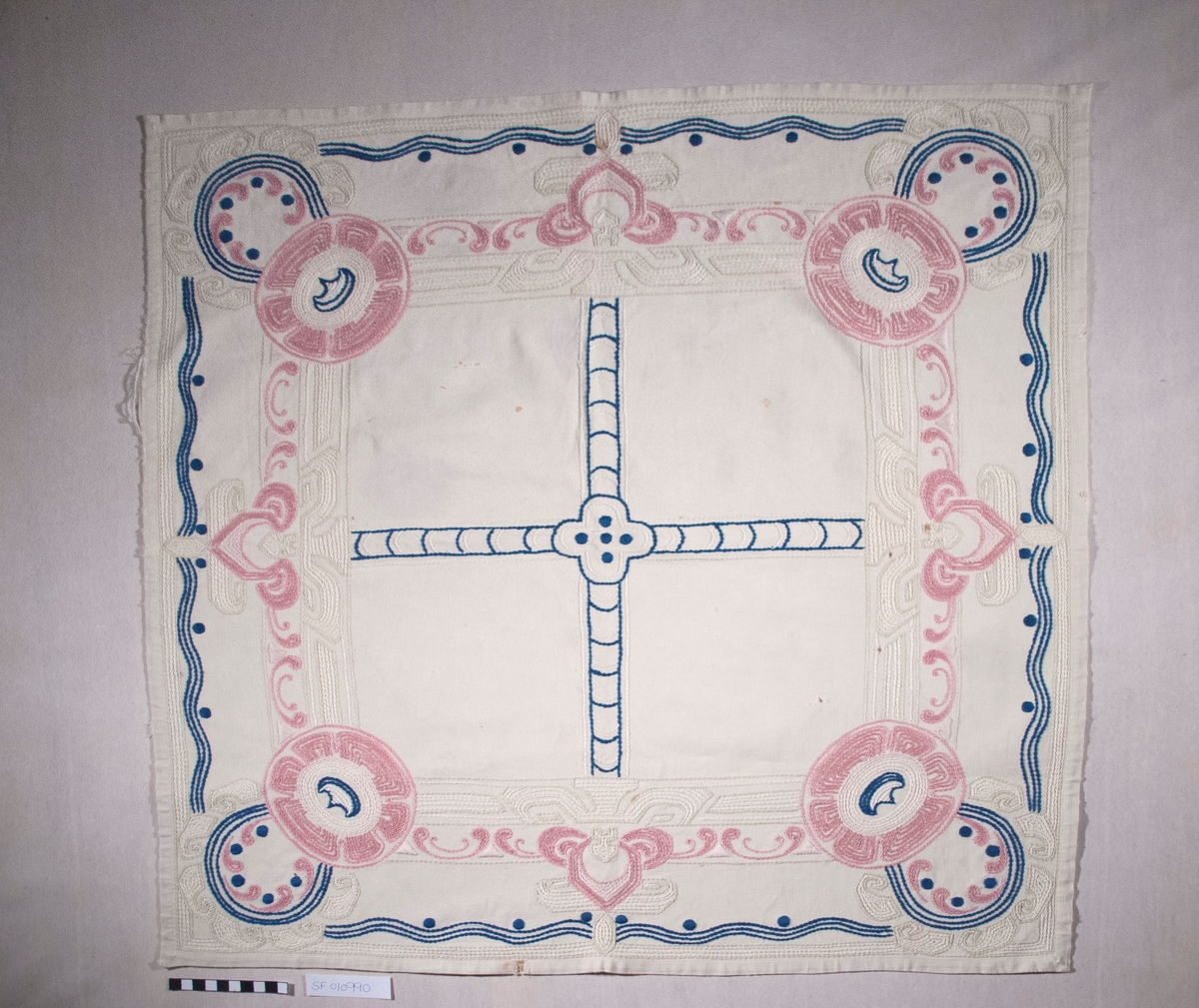 Bomullslerret, falda og brodert med attersting.