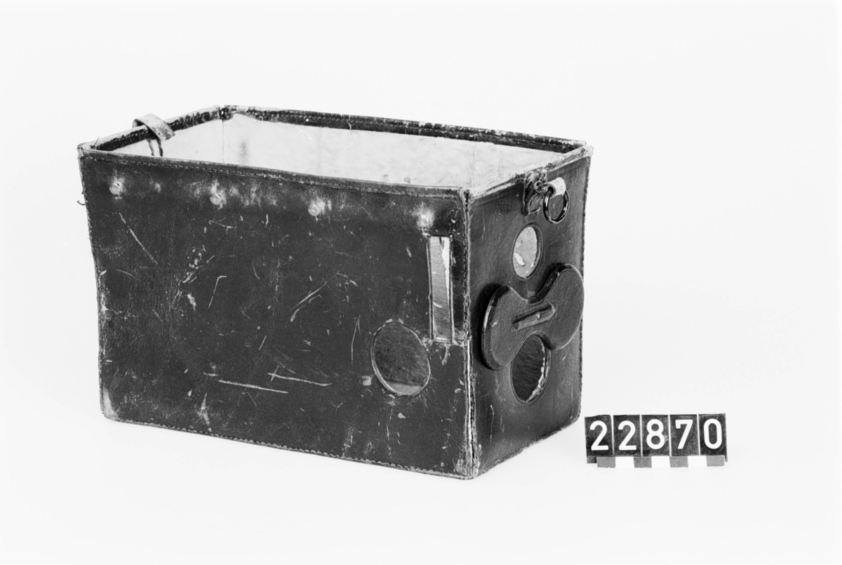 Lådkamera av trä, för plåtar 6.5 x 10 cm, i fodral av läder, med invändig plåtväxling. S.k. fallplåtskamera. Originell plåtväxling (troligen patent). Stor brilljantsökare med uppfällbart bländskydd, roterande skivbländare, skilda knappar för tids- och momentexponering samt plåträknare. Ögonblicksslutare. 30 st metallplåtar
Tillbehör: Kamera, fodral av läder samt 30 plåthållare av svart bleckplåt.