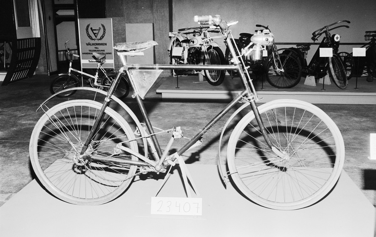Herrcykel av typ upp-och-nertrampare (till skillnad från rundtrampare). Upp-och-nedgående pedaler med kedjor till baknavet som är en s.k. rullspärr enl. Birger Ljungströms konstruktion, patenterad 1892. Rullspärren ger frihjulsfunktion. De fram-och-återgående kedjorna ger baknavet en roterande rörelse genom två excentriska "drivskivor". Fem tryckluftsreglerade växlar. På styret finns två gummiblåsor dolda under metallhöjle. Luften leds med slangarna till ytterliggare två gummiblåsor placerade på segmenten vid tramporna. Broms på bakhjulet genom att de båda tramporna trycks ned och påverkar en hävarm som trycker två roterande koniska bromsklotsar mot bakdäcket. Senare modell hade s.k. skedbroms mot bakdäcket. Framhjulsbroms med s.k. skedbroms mot framdäcket. Fälgar och skärmar av trä.
Tillbehör: Verktygsväska, signalklocka, skylt med polisens ordningsnr, 6808.