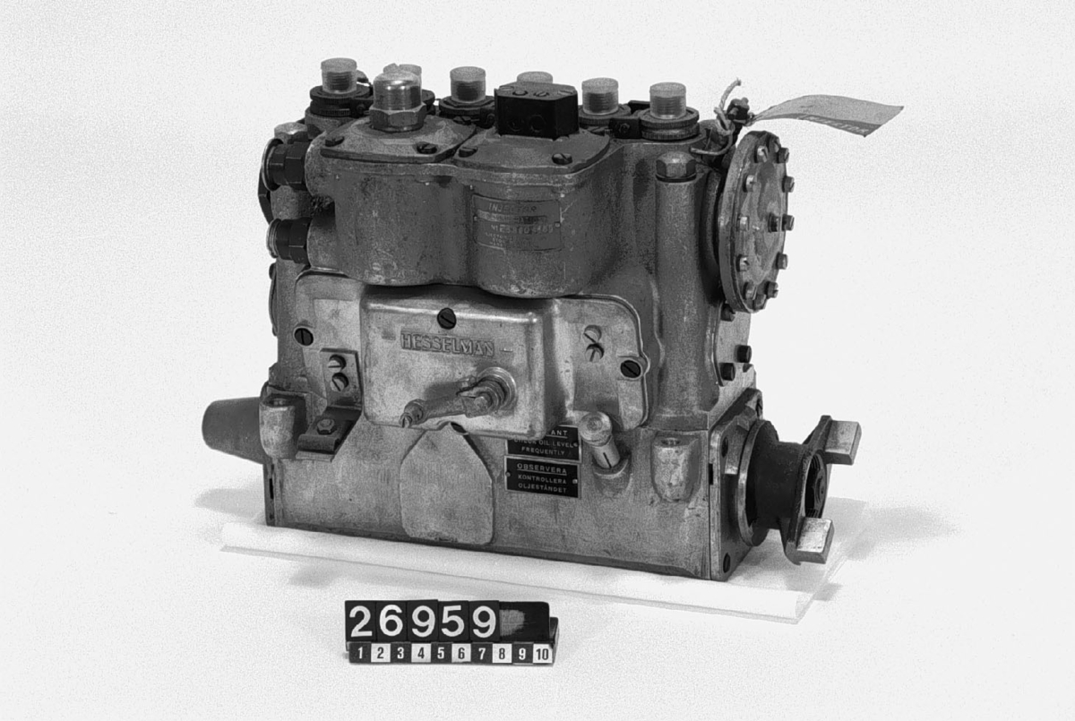 Sexcylindrig B-pump, för insprutning av bränsle i motorcylindrar. Med inbyggd vakuumregulator och elektromagnet för urkoppling av tre cylindrar i tomgång. Skylt: "Injector P6B6OB-169 Demonstration"_____ "Gjutet: "HESSELMAN". Etikett: "35 Volvo Penta" (blyerts). Konstruerad år 1935.