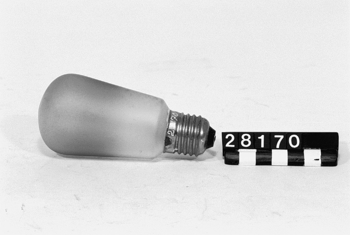 Elektrisk glödlampa med metalltråd, normal gänga, för 110 Volt, 25 Watt, basevakuerad, yttermatterad rak päronkolv. Etsat på globen: "Skandia 110-25 W (2)".