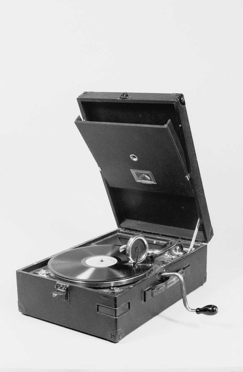 Resegrammofon, klädd md svart konstläder. Ljuddosa av fabriksmärket HMV 4.