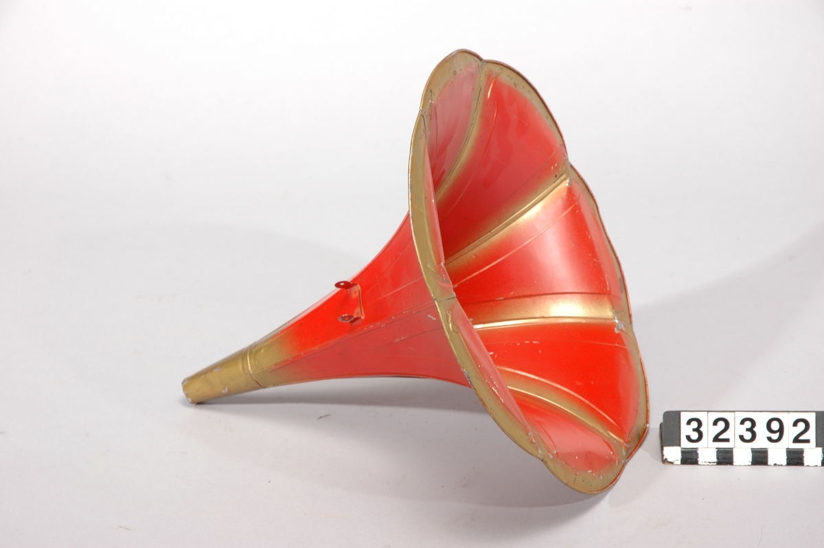 Fonograf med 3 trattar. Märkt: T A Edison, et als. Orange, NJ, USA Ljuddosa Recorder. Grönbetsad. Trattmåtten: den blanka L:535mm, Diam,311mm,B:400mm, Vikt:1,15kg. den röd/guldfärgade, L250mm,Diam:261mm, vikt:0,15kg.
Består av TM32392:1-4