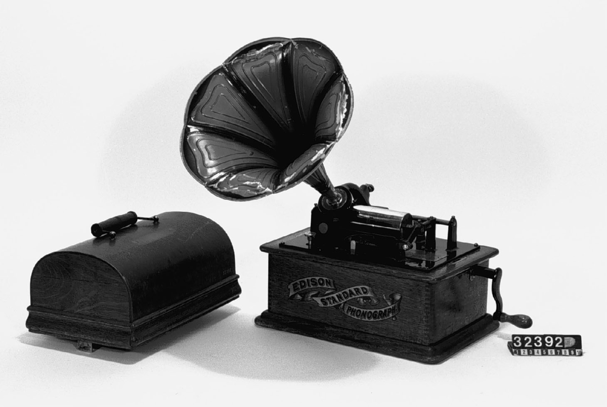 Fonograf med 3 trattar. Märkt: T A Edison, et als. Orange, NJ, USA Ljuddosa Recorder. Grönbetsad. Trattmåtten: den blanka L:535mm, Diam,311mm,B:400mm, Vikt:1,15kg. den röd/guldfärgade, L250mm,Diam:261mm, vikt:0,15kg.
Består av TM32392:1-4