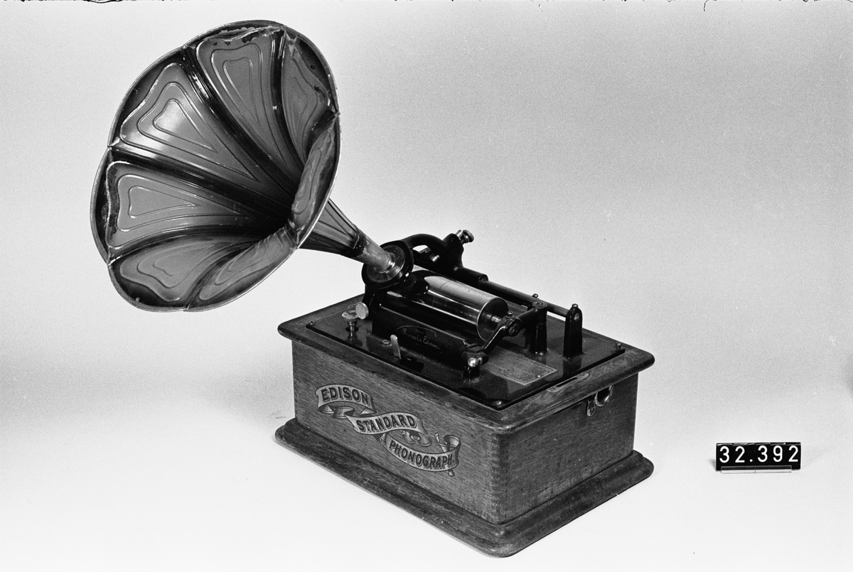 Fonograf med 3 trattar. Märkt: T A Edison, et als. Orange, NJ, USA Ljuddosa Recorder. Grönbetsad. Trattmåtten: den blanka L:535mm, Diam,311mm,B:400mm, Vikt:1,15kg. den röd/guldfärgade, L250mm,Diam:261mm, vikt:0,15kg.
Består av TM32392:1-4