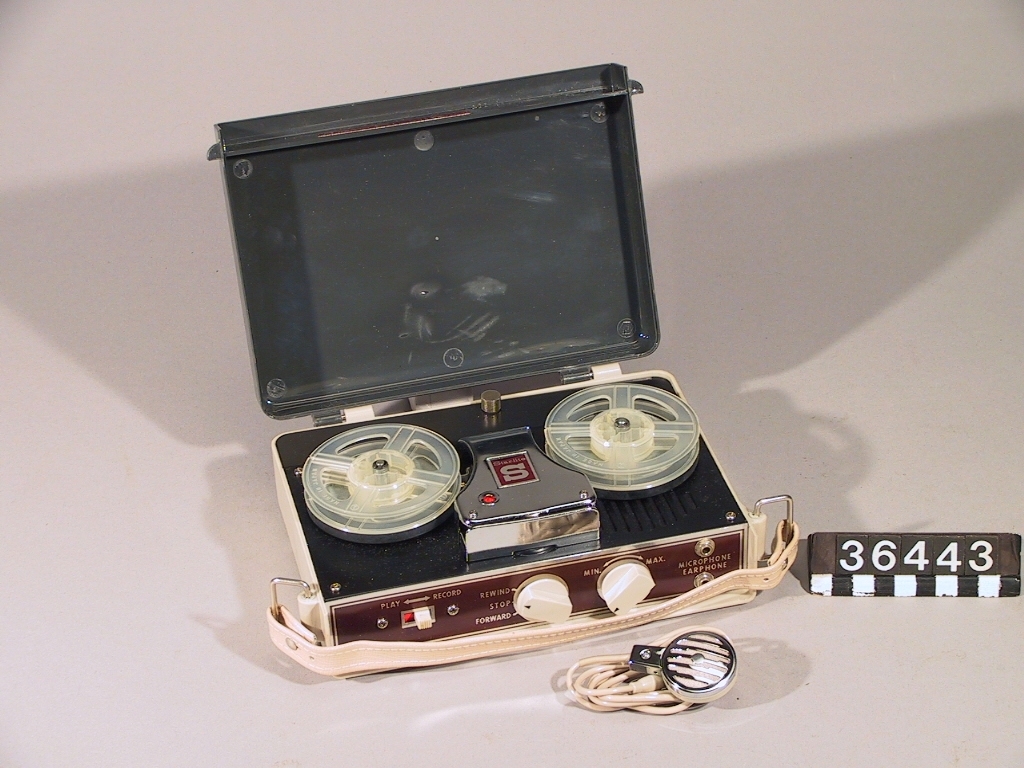 Batteridriven bandspelare med bärhandtag och mikrofon. Drives med 2 st. motorbatterier märke "C", samt ett 9 volt förstärkarbatteri. 2 st spolar för 6 mm band.