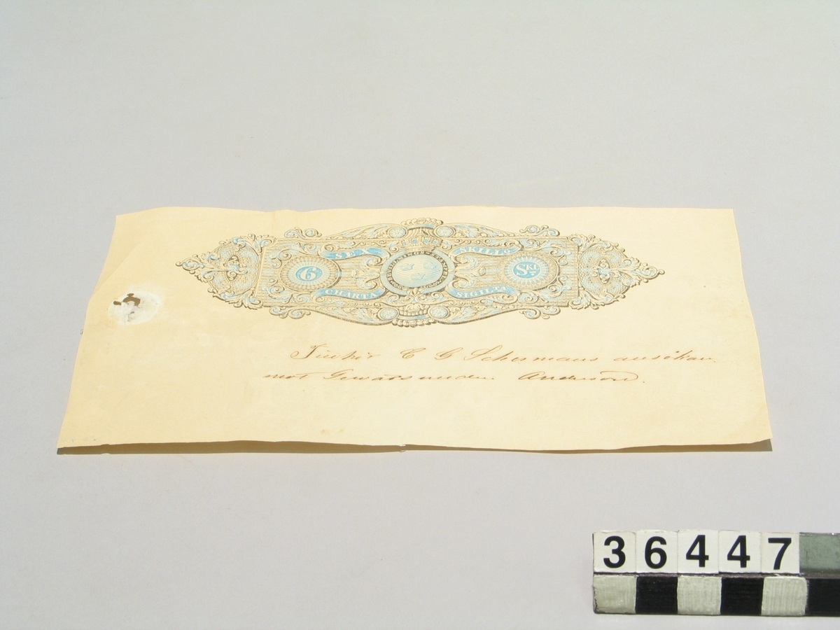 Del av pappersark med tryckt stämpel: Bevillningsstämpel, Charta Sigillata, 6 skillingar. Vattenmärke: R. ST. CH. SIG. TUMBA 6 SK 1853.