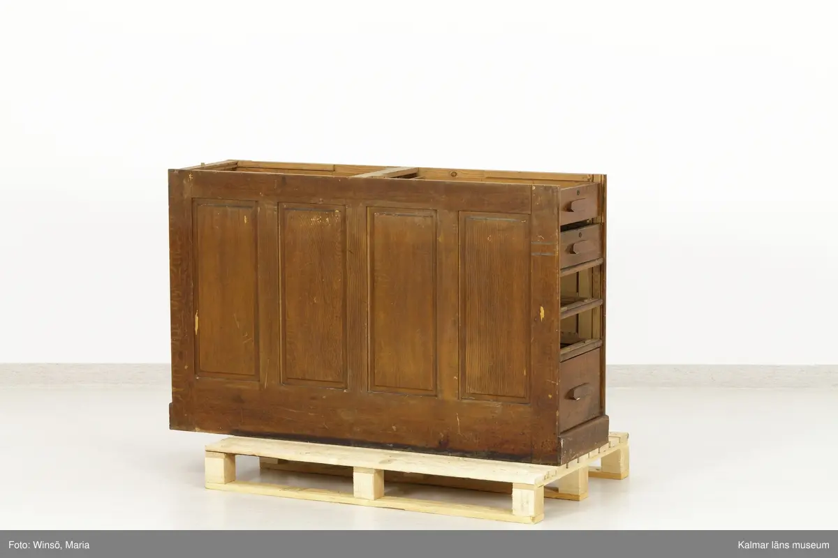 KLM 45471:1-2. Hurts, skrivbordshurts. Två stycken. Avlång hurts utan överdel. Av trä, ådringsmålad i ljusbrun kulör. Hurts :1 har på vardera kortsida en dörr med inbyggt lås. Inuti utrymmena diverse fack och hyllor. På ena långsidan en dubbeldörr med inbyggt lås. Utrymmet är indelat i två fack och åtta hyllplan. På några av hyllplanens främre kant är skrivet: Normal-skrivpapper, Skrivpapper 375x480, Postpapper 47 ark, Läskpapper 8 ark. Hurts :2 har på vardera kortsida utdragbara lådor, ett flertal saknas. Båda hurtsarna är försedda med spegeldörrar/väggar.