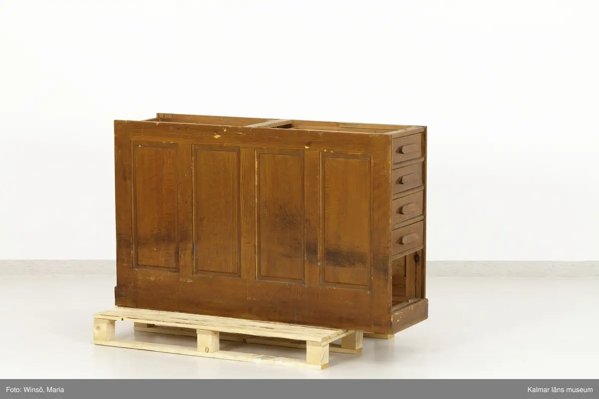 KLM 45471:1-2. Hurts, skrivbordshurts. Två stycken. Avlång hurts utan överdel. Av trä, ådringsmålad i ljusbrun kulör. Hurts :1 har på vardera kortsida en dörr med inbyggt lås. Inuti utrymmena diverse fack och hyllor. På ena långsidan en dubbeldörr med inbyggt lås. Utrymmet är indelat i två fack och åtta hyllplan. På några av hyllplanens främre kant är skrivet: Normal-skrivpapper, Skrivpapper 375x480, Postpapper 47 ark, Läskpapper 8 ark. Hurts :2 har på vardera kortsida utdragbara lådor, ett flertal saknas. Båda hurtsarna är försedda med spegeldörrar/väggar.