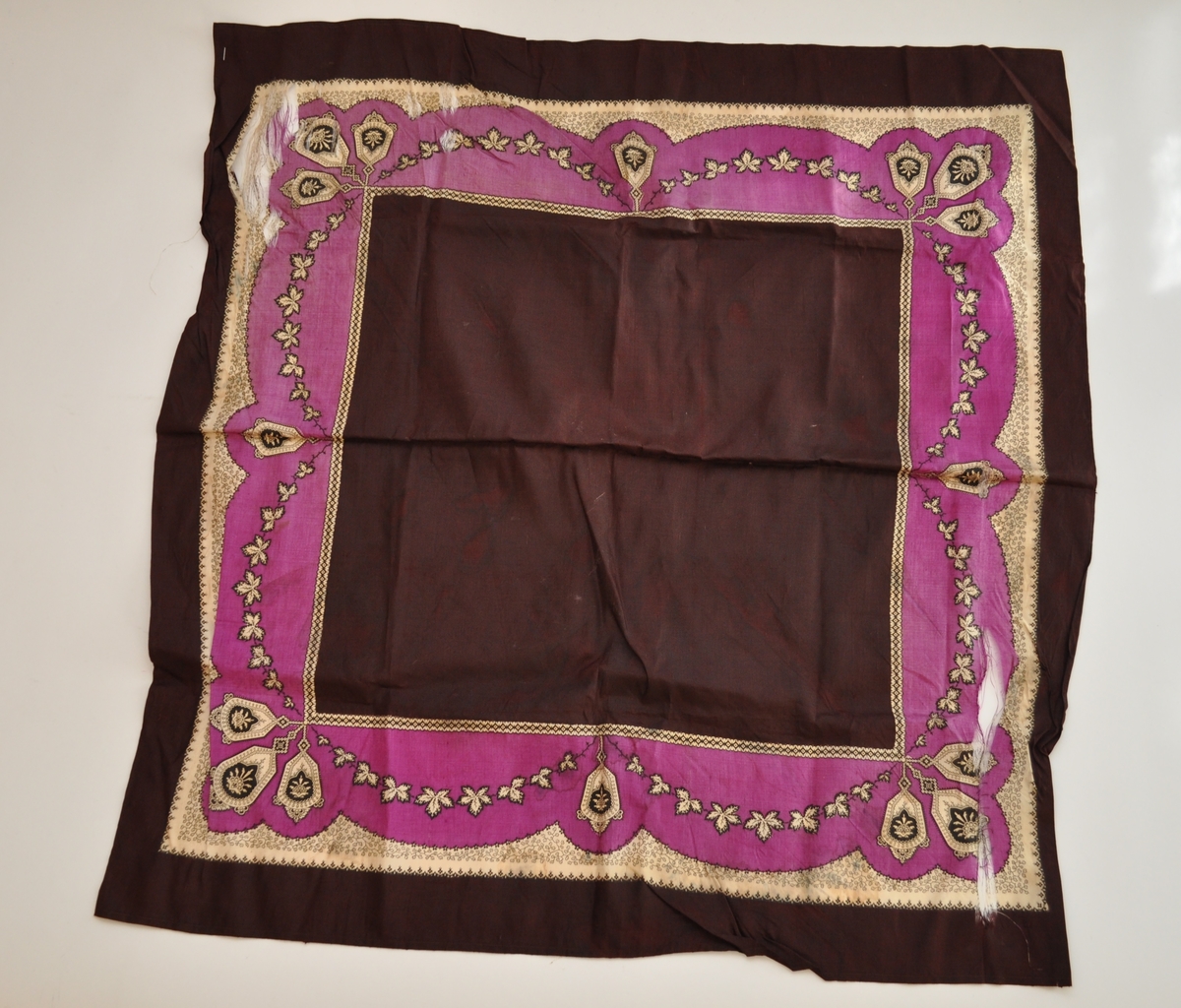 Bord langs alle fire kanter med bladverk, stiliserte blomster og geometriske figurer.