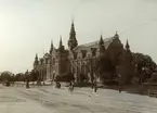 Nordiska museet. En ryttare och en hästvagn på vägen framför museet.