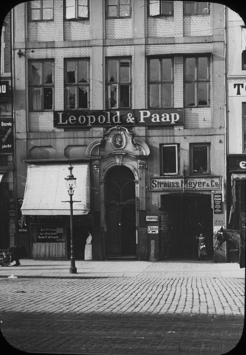 Skioptikonbild med motiv från Gänsemarkt i Hamburg.
Bilden har förvarats i kartong märkt: Resan 1906. Hamburg 9.