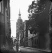 Skioptikonbild med motiv från Baden strasse i Stralsund. I bakgrunden syns St. Nikolai Kirche.
Bilden har förvarats i kartong märkt: Resan 1912. Stralsund. 9. Text på bild: 